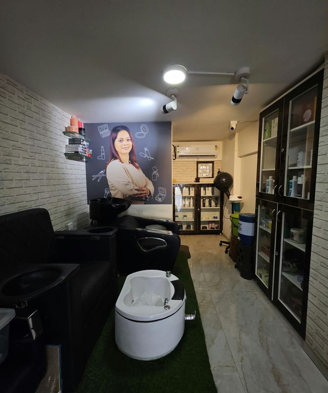 Hair-wash station beside a portrait wall and product shelves